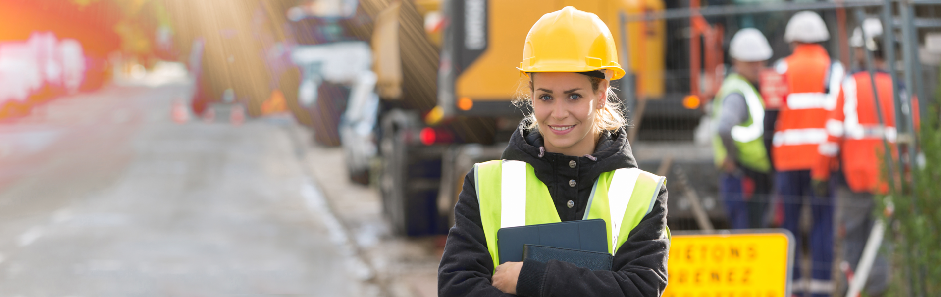 Construction worker holding a tablet on a construction site.